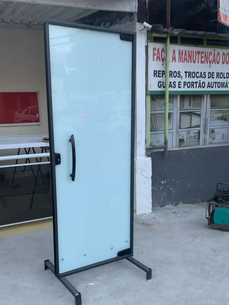 Porta de vidro jateado com quadro de ferro preto em frente à loja